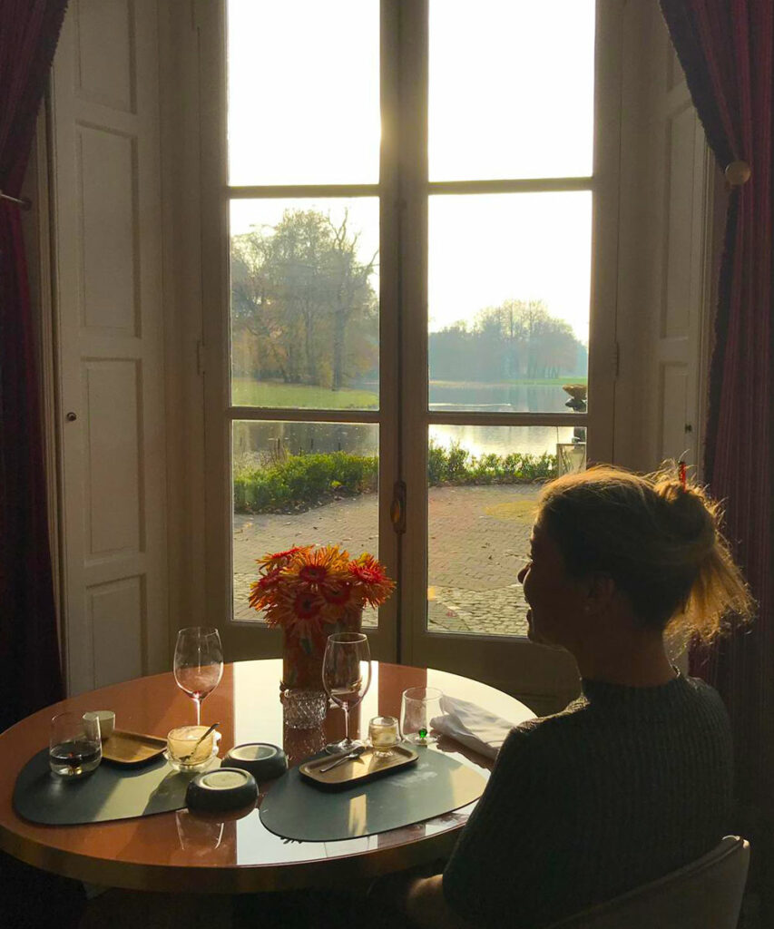 Blind painter Laura Meddens sits at a round table in Restaurant Voltaire with a view of the pond where she skated as a child in the winter.