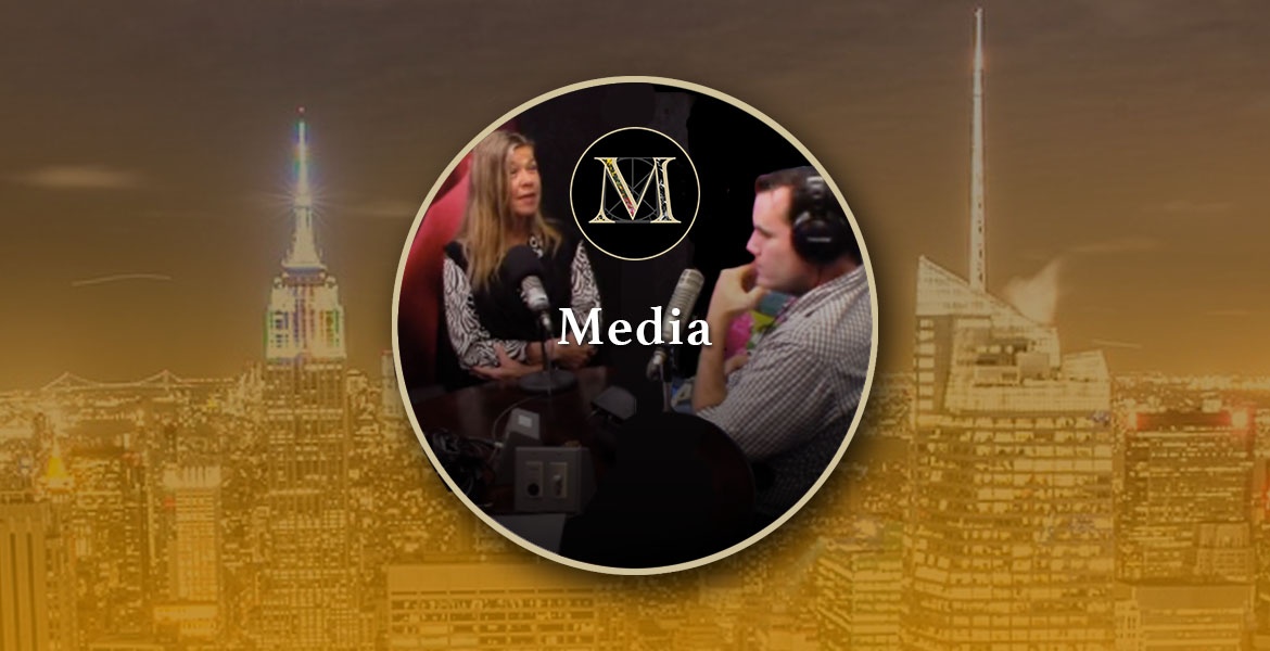 Media. Photo of Laura Meddens being interviewed by Mark Farrell in New York City inside the gold ring icon logo with a nighttime cityscape of New York in the background.